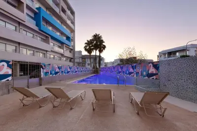 a group of chairs sitting next to a swimming pool at UC Hall Residence in Nicosia