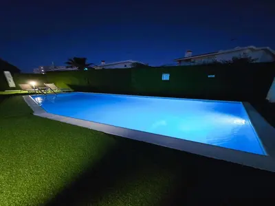 a large blue swimming pool in a yard at night at 3 Bedroom Villa, private pool, hot tub in Protaras