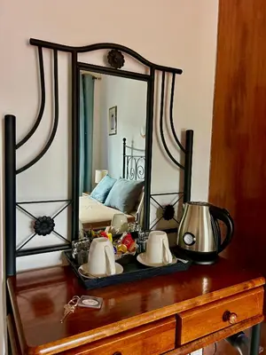 a mirror on top of a wooden dresser at Two Flowers Hotel in Pedoulas