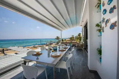 a dining room with a table and a view of the ocean at Sunprime Protaras Beach - Adults Only in Protaras