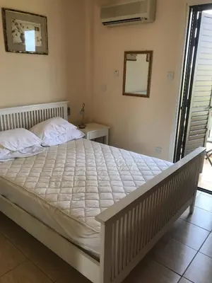 a large bed in a bedroom with a mirror at Limni Pool House B in Larnaka