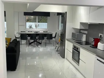 a kitchen and living room with a table and chairs at Konnos Hight Villa in Protaras