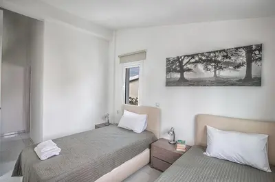 a bedroom with two beds and a picture on the wall at Konnos Hight Villa in Protaras