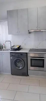 a kitchen with a stove and a washing machine at Delphi Court - large 1 bed -sleeps 4, Near sea/beach - free wifi in Limassol