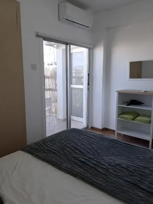 a white bedroom with a bed and a balcony at Delphi Court - large 1 bed -sleeps 4, Near sea/beach - free wifi in Limassol