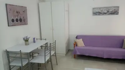 a living room with a purple couch and a table at LCA4 flat for you apartment in Larnaka