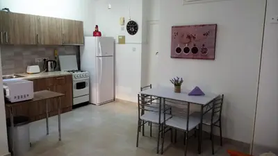 a kitchen with a white refrigerator and a table with chairs at LCA4 flat for you apartment in Larnaka