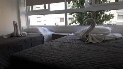 two beds with swans towels on them in a bedroom at LCA4 flat for you apartment in Larnaka
