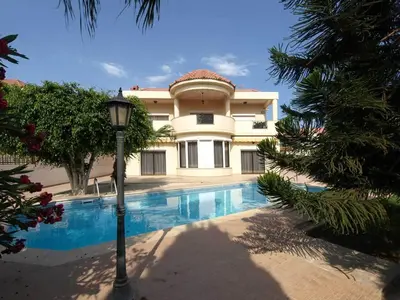 a large house with a swimming pool in front of it at Patatas Villa in Limassol