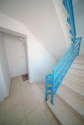 a blue staircase in a white room with a blue rail at The Blue Mile w Jacuzzi in Paralimni