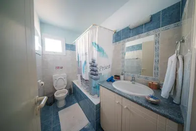 a bathroom with a sink and a toilet at The Blue Mile w Jacuzzi in Paralimni