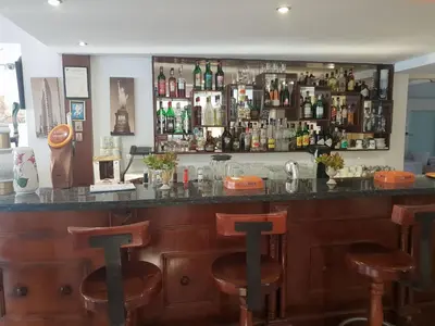 a bar with wooden bar stools in a room at Cornelia Hotel in Ayia Napa