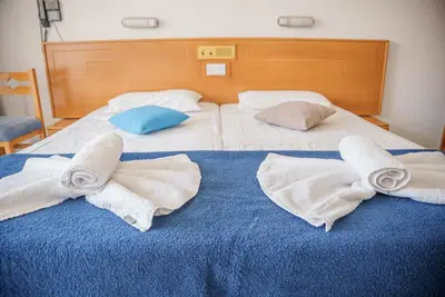 two beds with towels and pillows on them at Cornelia Hotel in Ayia Napa