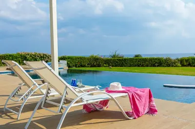 a table and chairs sitting next to a swimming pool at Infinity Villa in Protaras