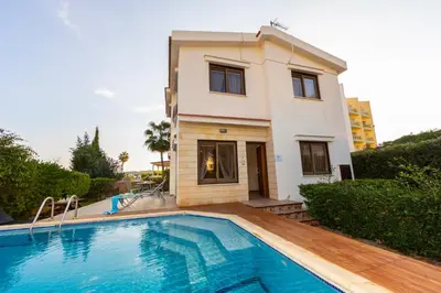 a villa with a swimming pool in front of a house at Buena Vista Villa in Protaras