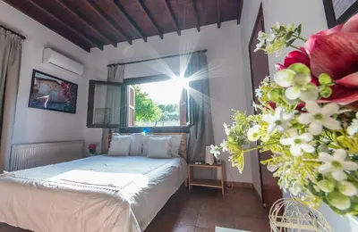 a bedroom with a bed and a window and flowers at Lefkara Villa in Kato Lefkara