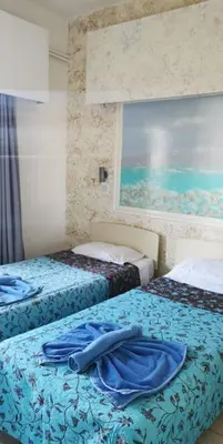a bedroom with two beds with blue sheets at Simos Magic Hotel Apts in Ayia Napa