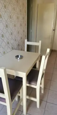 a white table with two chairs and a refrigerator at Simos Magic Hotel Apts in Ayia Napa
