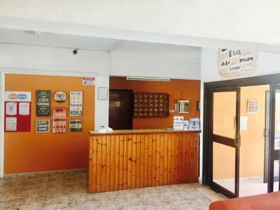 a restaurant with a counter in a room with orange walls at Carina Hotel Apartments in Ayia Napa