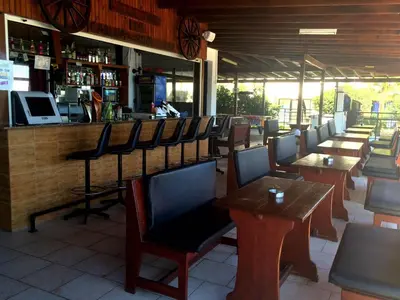 a restaurant with tables and chairs and a bar at Carina Hotel Apartments in Ayia Napa