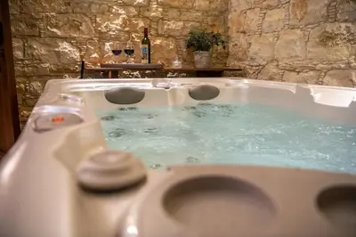 a bath tub filled with blue water in a bathroom at Apanemia Inn Studio in Lofou