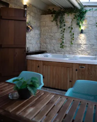 a bathroom with a tub and two chairs and a table at Apanemia Inn Studio in Lofou