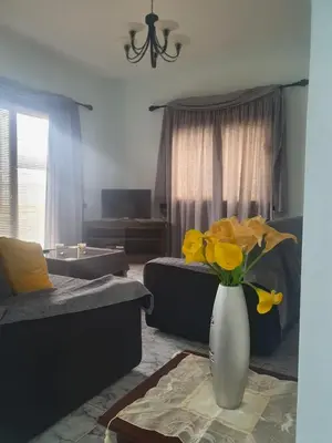 a living room with a vase of yellow flowers on a table at House on the hill in Xylophaghou