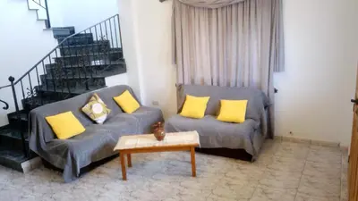 a living room with a couch and yellow pillows at House on the hill in Xylophaghou