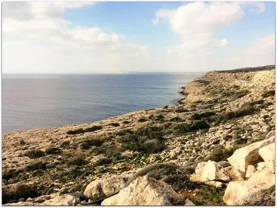 a rocky shore with the ocean in the background at House on the hill in Xylophaghou