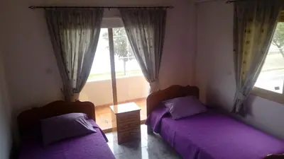 two beds in a bedroom with purple sheets and a window at House on the hill in Xylophaghou