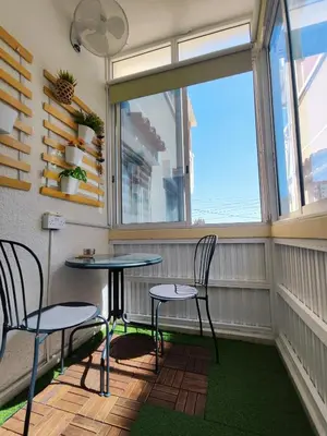 a balcony with two chairs and a table and a window at Elena Holiday Apartment in Larnaka