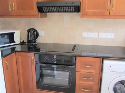 a kitchen with a black stove and a microwave at Villa Jade in Paralimni
