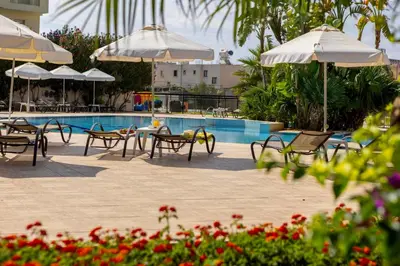 a group of chairs and umbrellas next to a swimming pool at Seagull Hotel Apartments in Protaras