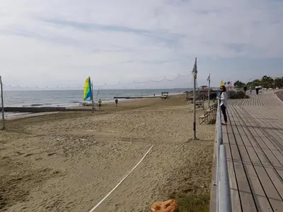 a person standing on a beach with the ocean at Haig's Dream Flat On The Beach in Larnaka