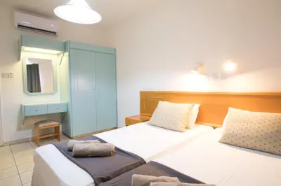 a bedroom with two beds and a mirror at DebbieXenia Hotel Apartments in Protaras