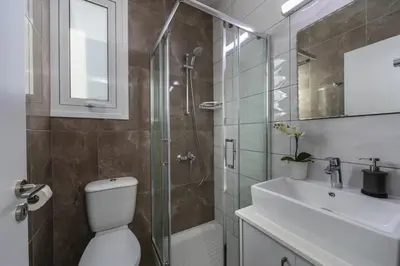 a bathroom with a shower and a toilet and a sink at Protaras Villa Araella in Ayia Napa