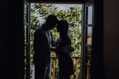 a man and a woman standing in front of a window at Oinou Strata - Adults Only in Vouni