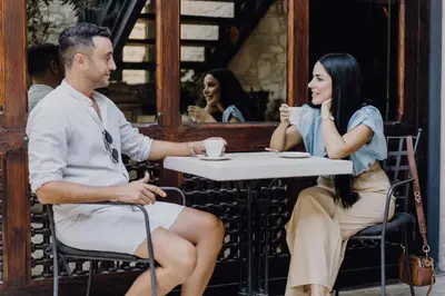 a man and woman sitting at a table in a cafe at Oinou Strata - Adults Only in Vouni
