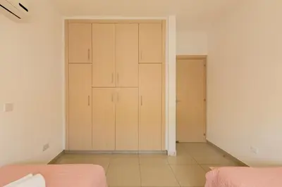 a bedroom with two closets with pink sheets at Oceania Bay Village in Pyla