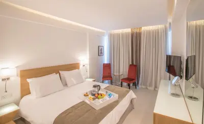 a hotel room with a bed with a tray of fruit on it at Kokkinos Boutique Hotel in Protaras