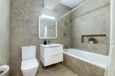 a bathroom with a white toilet and a tub and a sink at Mediterranean Sunrise Complex in Voroklini
