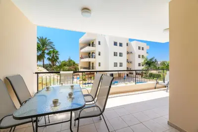 a table and chairs on a balcony with a view of a building at Mediterranean Sunrise Complex in Voroklini