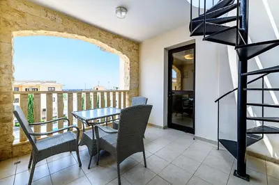 a dining room with a table and chairs and a balcony at Blue Serenity Complex in Larnaka