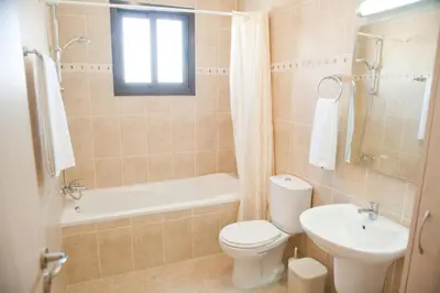 a bathroom with a toilet and a tub and a sink at Blue Serenity Complex in Larnaka