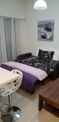 a bedroom with a bed and a table and a chair at By The Way Apartment in Larnaka