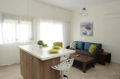 a kitchen and living room with a couch and a table at By The Way Apartment in Larnaka