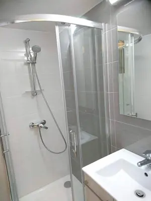 a shower with a glass door next to a sink at By The Way Apartment in Larnaka