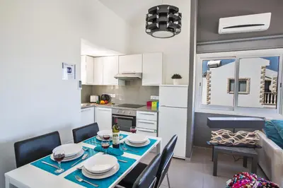 a kitchen and dining room with a table and chairs at Nicholas Seaview Apartments in Protaras