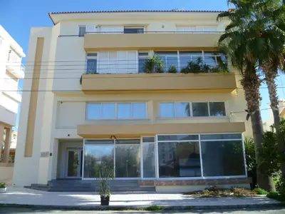 a white building with windows and palm trees at Private deluxe room with balcony at Datacom building in Nicosia
