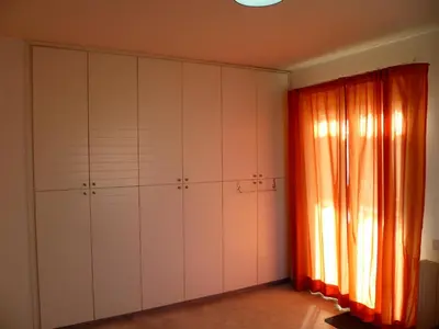 a room with a large closet with an orange curtain at Private deluxe room with balcony at Datacom building in Nicosia